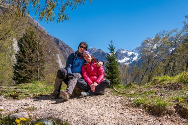 Dağ çayırında ağaçlarla çevrili mutlu çift pozu. Karı koca doğada dinleniyor..