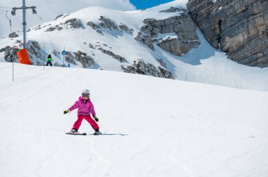 Güzel bir genç kız güneşli bir günde kış otelinde kayak yapmayı öğreniyor. Dağlarda aktif bir çocukluk.
