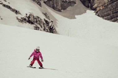 Güzel bir genç kız güneşli bir günde kış otelinde kayak yapmayı öğreniyor. Dağlarda aktif bir çocukluk.