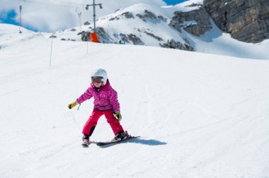 Güzel bir genç kız güneşli bir günde kış otelinde kayak yapmayı öğreniyor. Dağlarda aktif bir çocukluk.