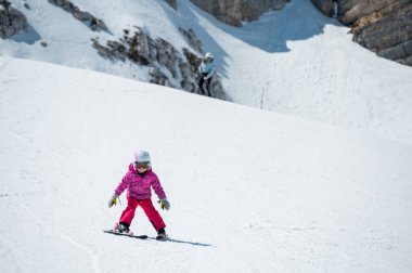 Güzel bir genç kız güneşli bir günde kış otelinde kayak yapmayı öğreniyor. Dağlarda aktif bir çocukluk.