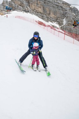 Baba ve kızı, Dağ Tepesi 'ndeki bir kayak merkezinde ilk adımlarını atarak eğleniyor ve kayak öğreniyor. Kış boyunca aktif çocukluk.