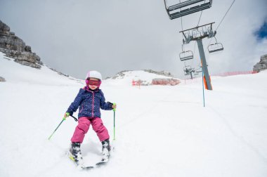 Güneşli bir günde, kış otelinde kayak yapmayı öğrenen tatlı bir genç kız. Aktif kış tatili.