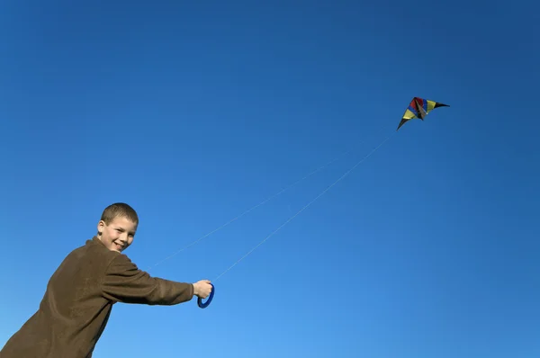 Menino voando um papagaio longe inclinado — Fotografia de Stock