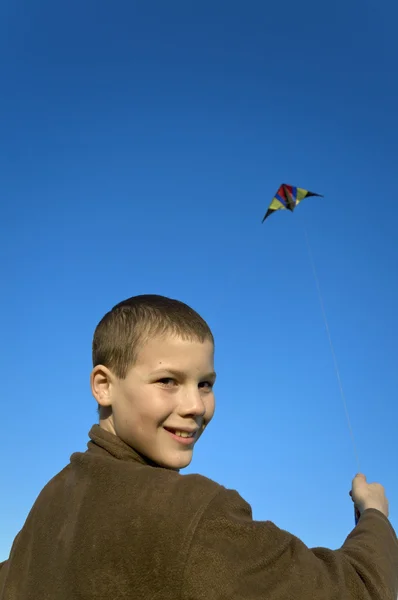 Pojke flyger en drake nära ansikte — Stockfoto