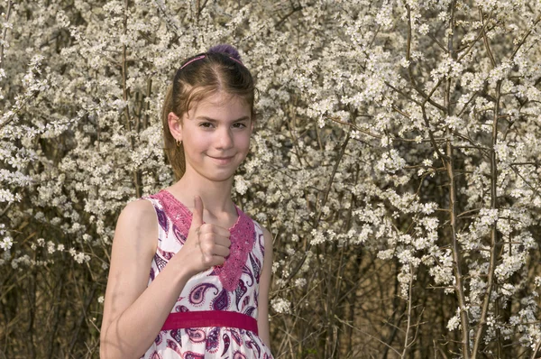 Flicka med vita blommor visar ok — Stockfoto