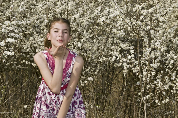 Flicka med vita blommor kasta kyss — Stockfoto