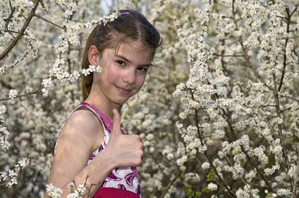 Ok gülümseyen gösterilen beyaz çiçekler kızın — Stok fotoğraf