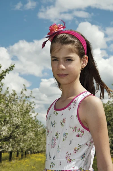 Meisje in de boomgaard van de zure kers op zoek sulky — Stockfoto