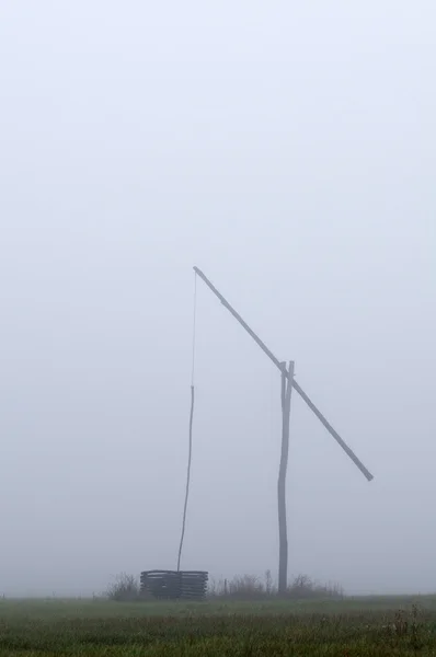 Shadoof in fog vertical — Stock Photo, Image