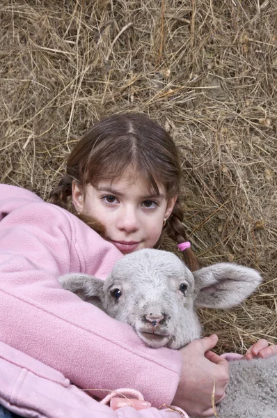 Meisje met lam in het hooi站在休旅车里面的姐妹 Rechtenvrije Stockfoto's