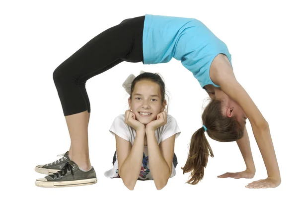 Young woman in bridge pose with other woman under her — Stock Photo, Image