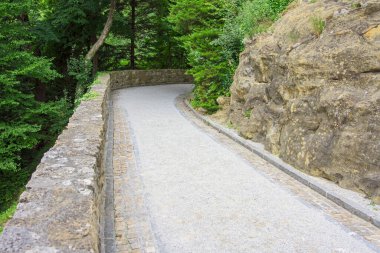 Yamacın yamacına taş duvarlarla oyulmuş dar bir yol var.