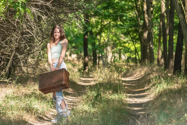 Genç Bir Kadın Eski Kahverengi Bavuluyla Orman Yolunda Dikiliyor — Stok fotoğraf