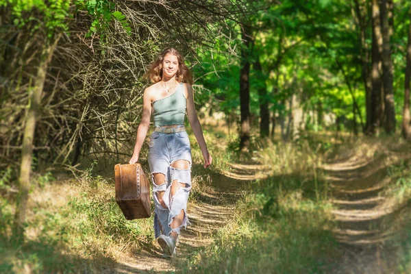 Genç Bir Kadın Eski Kahverengi Bavuluyla Orman Yolunda Yürüyor — Stok fotoğraf