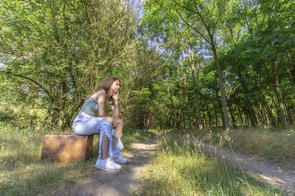 Jovem Mulher Sentada Uma Velha Mala Marrom Estrada Terra Floresta — Fotografia de Stock