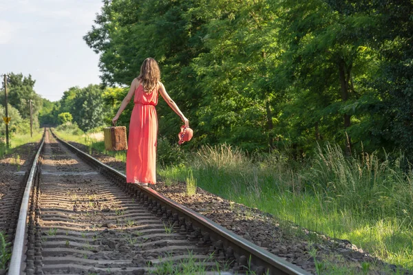 Giovane Donna Abito Rosso Equilibrio Rotaie Con Vecchia Valigia Marrone — Foto Stock