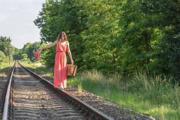 Молодая Женщина Красном Платье Балансирует Рельсах Старым Коричневым Чемоданом — стоковое фото