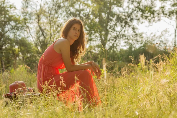 Junge Frau Rotem Kleid Sitzt Auf Koffer Und Blickt Wald — Stockfoto