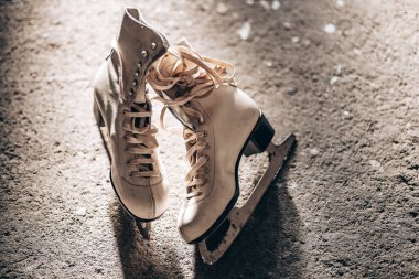 Pair of vintage white leather ice skates on the floor