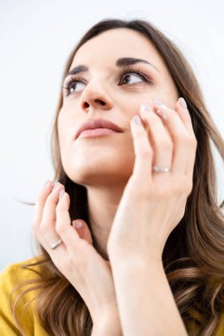 Genç bir kadının şehvetle yüzüne dokunuşunun yakın çekimi.