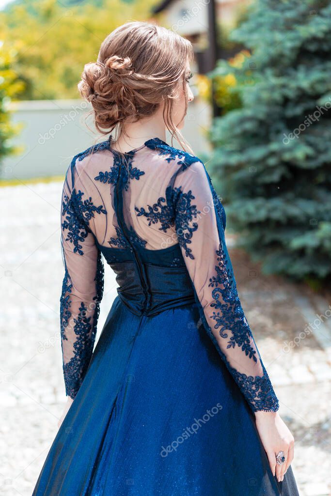 Back view of a girl in glamorous ultramarine dress. Ready for her prom night.