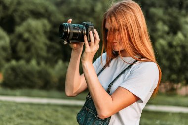 Kızıl ergen, kamerayla fotoğraf çeken kız.