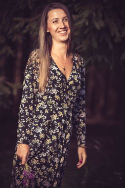 Genç, güzel esmer bir kızın yaz elbisesi içindeki portresi.