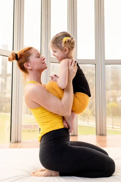 Young fit mom having loving time with her daughter