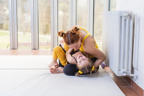 Young fit mom having loving time with her daughter