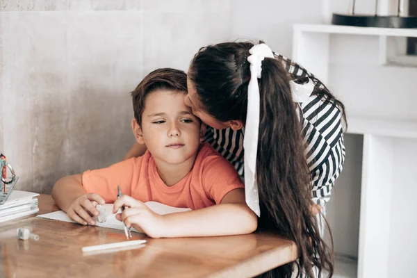 Little School Boy Doing Homework His Mom Kissing Him Head — Stock Photo, Image