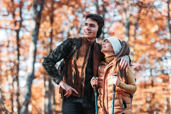 Young couple looking at something in the woods. Hiking, outdoors