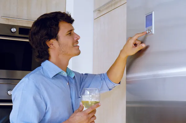 Человек смотрит на холодильник — стоковое фото