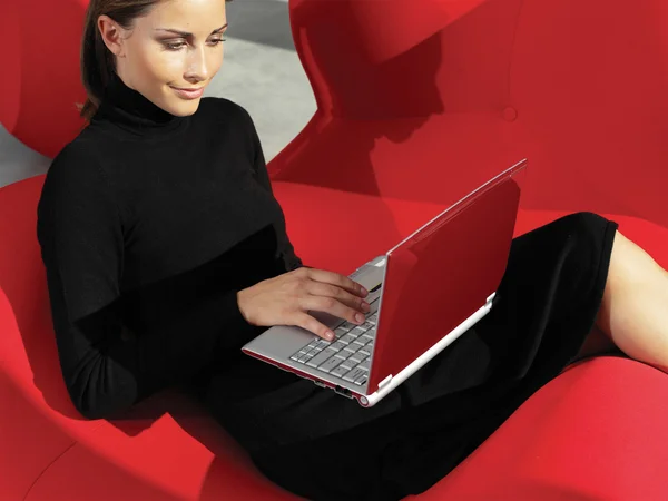 Woman with laptop on the sofa a — Stock Photo, Image