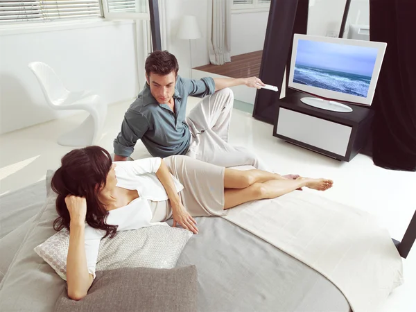 Pareja sentada en el sofá y viendo la televisión —  Fotos de Stock