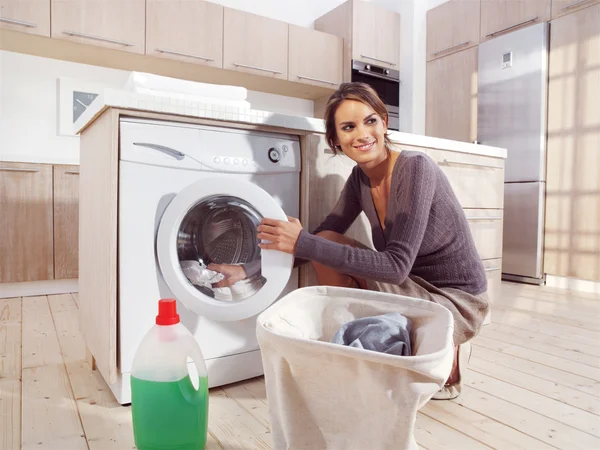 Mujer poniendo tela en la lavadora — Foto de Stock