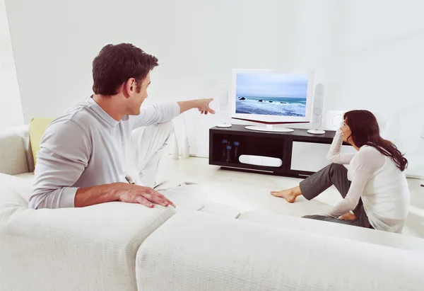 Couple sur canapé et regarder la télévision — Photo