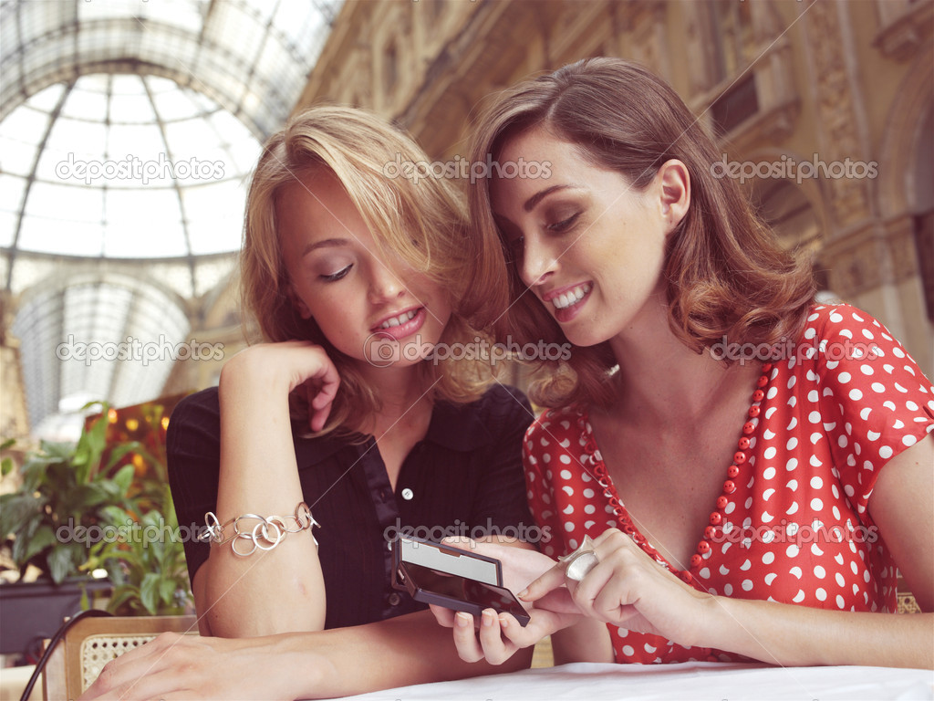 women look at message on mobile phone 