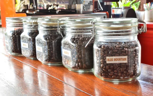Koffie graan in glazen flessen — Stockfoto