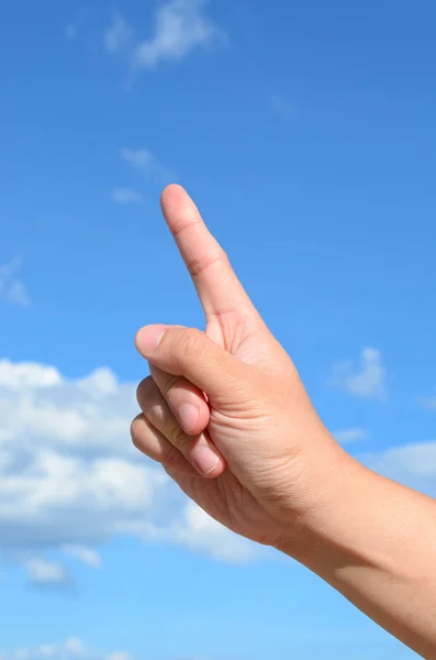 One finger of human hand on blue sky background — Stock Photo, Image