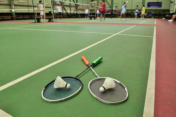 Badminton - two shuttlecocks on rackets in the badminton courts