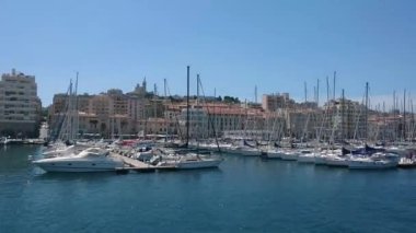 MARSEILLE, FRANCE 31 Mayıs 2021: Marsilya 'nın eski limanı (Vieux Limanı), yanından geçen ve içinde hiç insan olmayan çok sayıda yatı filme alan, pitoresk şehir manzarası, ünlü turizm beldesi