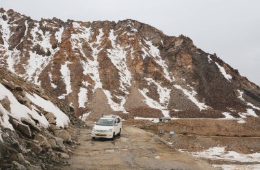 Ladakh, Hindistan - 18 Haziran 2015. Kuzey Hindistan, Ladakh 'ta dağ yolunda bir araba. Ladakh, Jammu ve Kashmir eyaletinin çorak ama güzel bir bölgesidir..