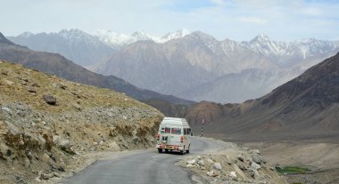 Ladakh, Hindistan - 18 Haziran 2015. Kuzey Hindistan, Ladakh 'ta dağ yolunda bir araba. Ladakh, Jammu ve Kashmir eyaletinin çorak ama güzel bir bölgesidir..