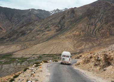 Ladakh, Hindistan - 18 Haziran 2015. Kuzey Hindistan, Ladakh 'ta dağ yolunda bir araba. Ladakh, Jammu ve Kashmir eyaletinin çorak ama güzel bir bölgesidir..