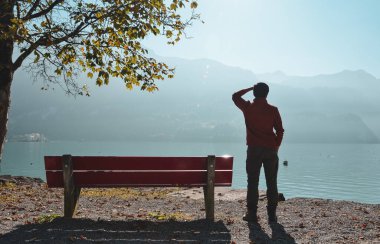 Yalnız bir adam güzel ve huzurlu bir göle bakıyor..