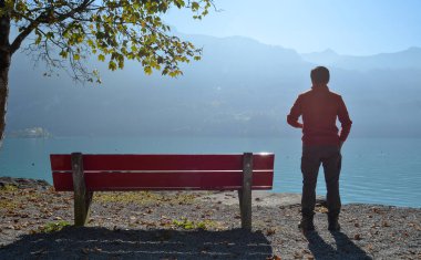 Yalnız bir adam güzel ve huzurlu bir göle bakıyor..