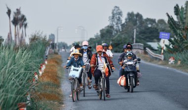 Dong Thap, Vietnam - 4 Ekim 2019. Lise öğrencileri Dong Thap, Vietnam 'da kırsal yolda bisikletle okula gidiyor..
