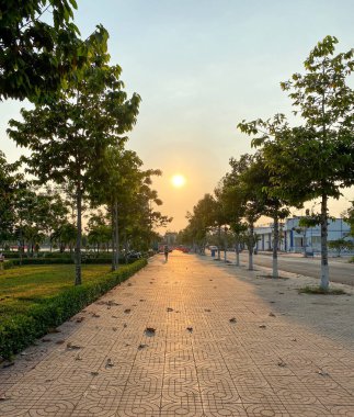 Saigon, Vietnam 'da gün batımının altında yeşil parkta yürüyüş yolu.