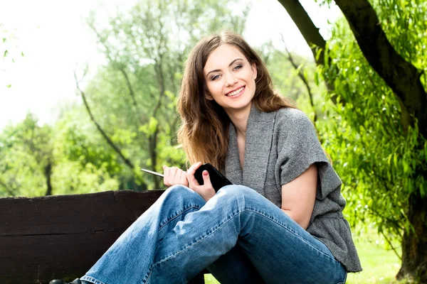 Bella donna che lavora con un tablet nel parco — Foto Stock